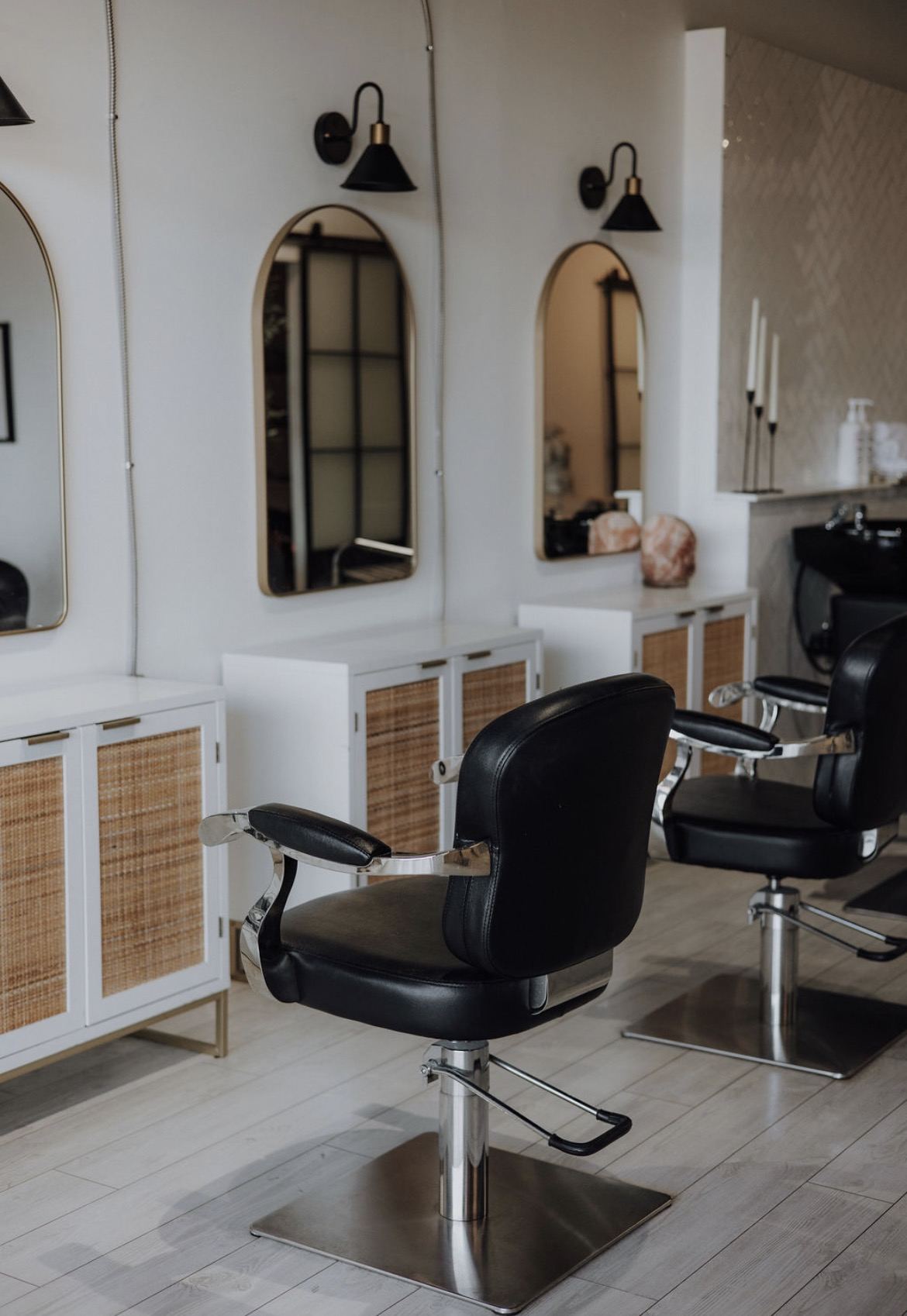 Arched gold mirrors above the styling stations