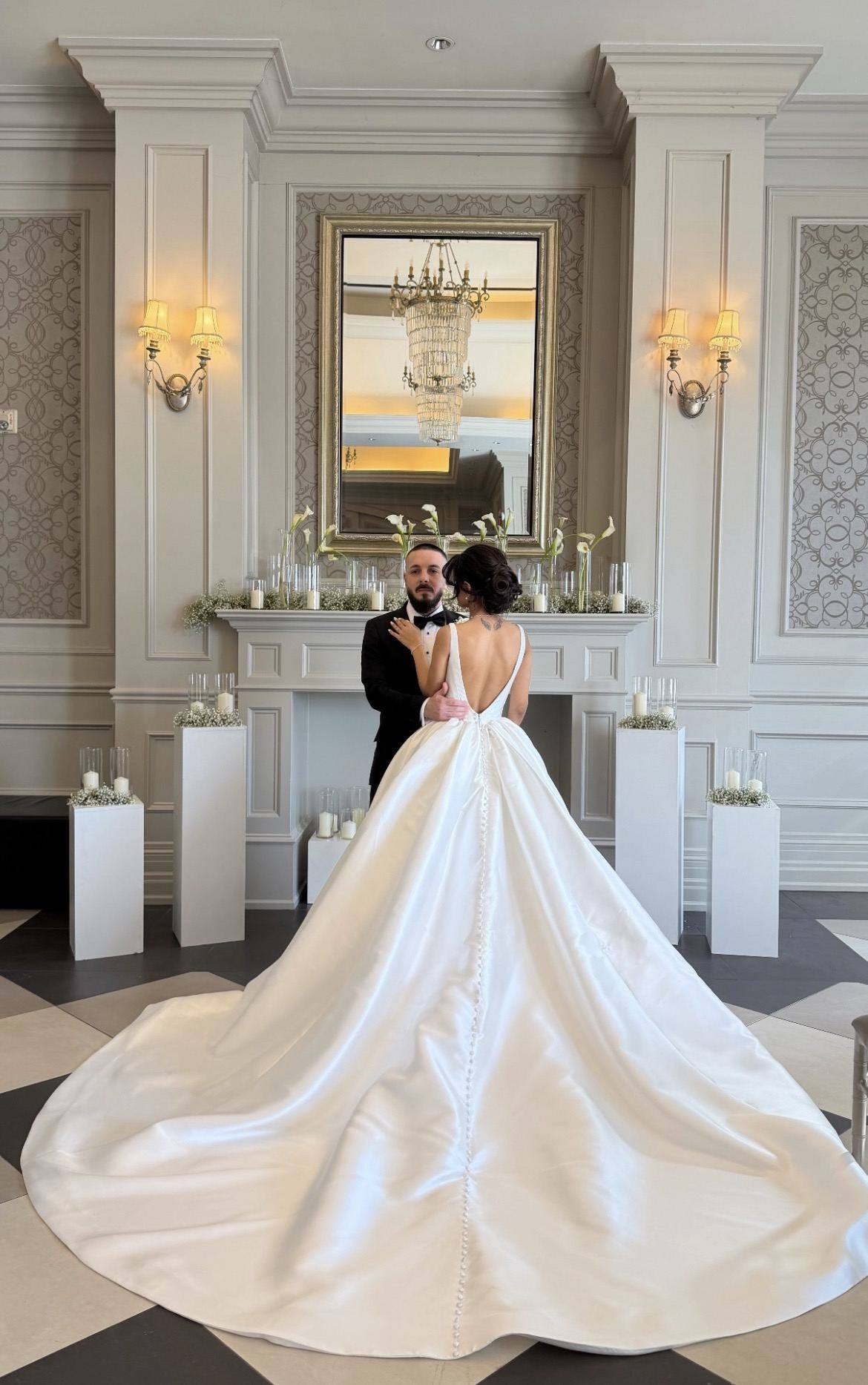 Bride in a grand ballroom, her satin train spread across the floor