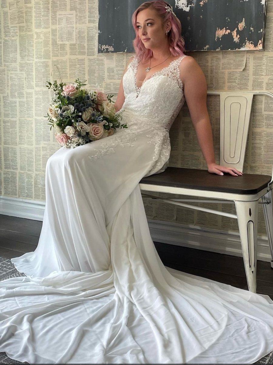 Bride with pink hair seated on a bench with her bouquet