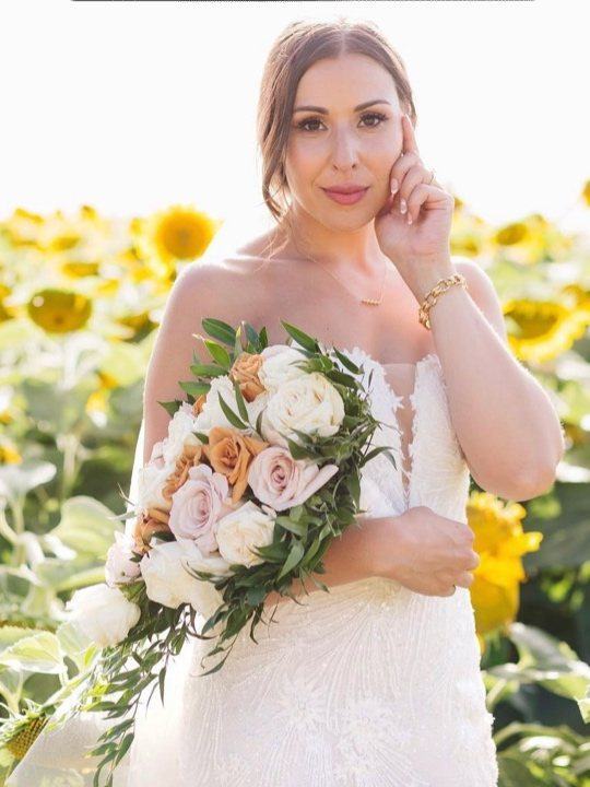 Bride holding her bouquet in a sunflower field