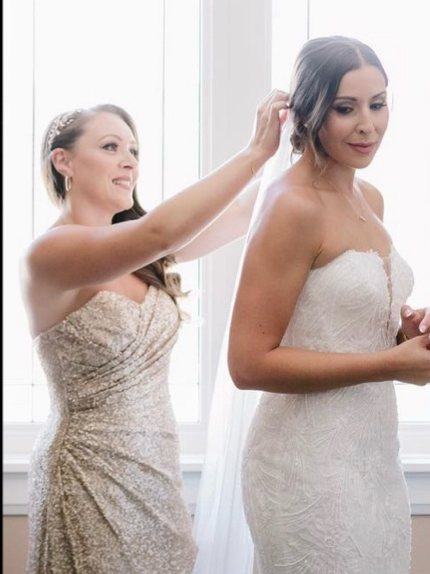 A woman setting the bride’s veil in place