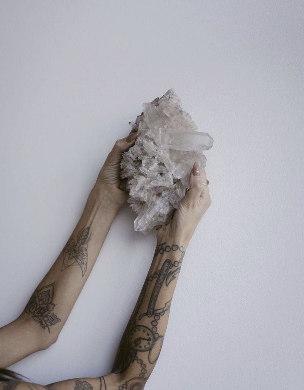 Hands holding a raw crystal cluster