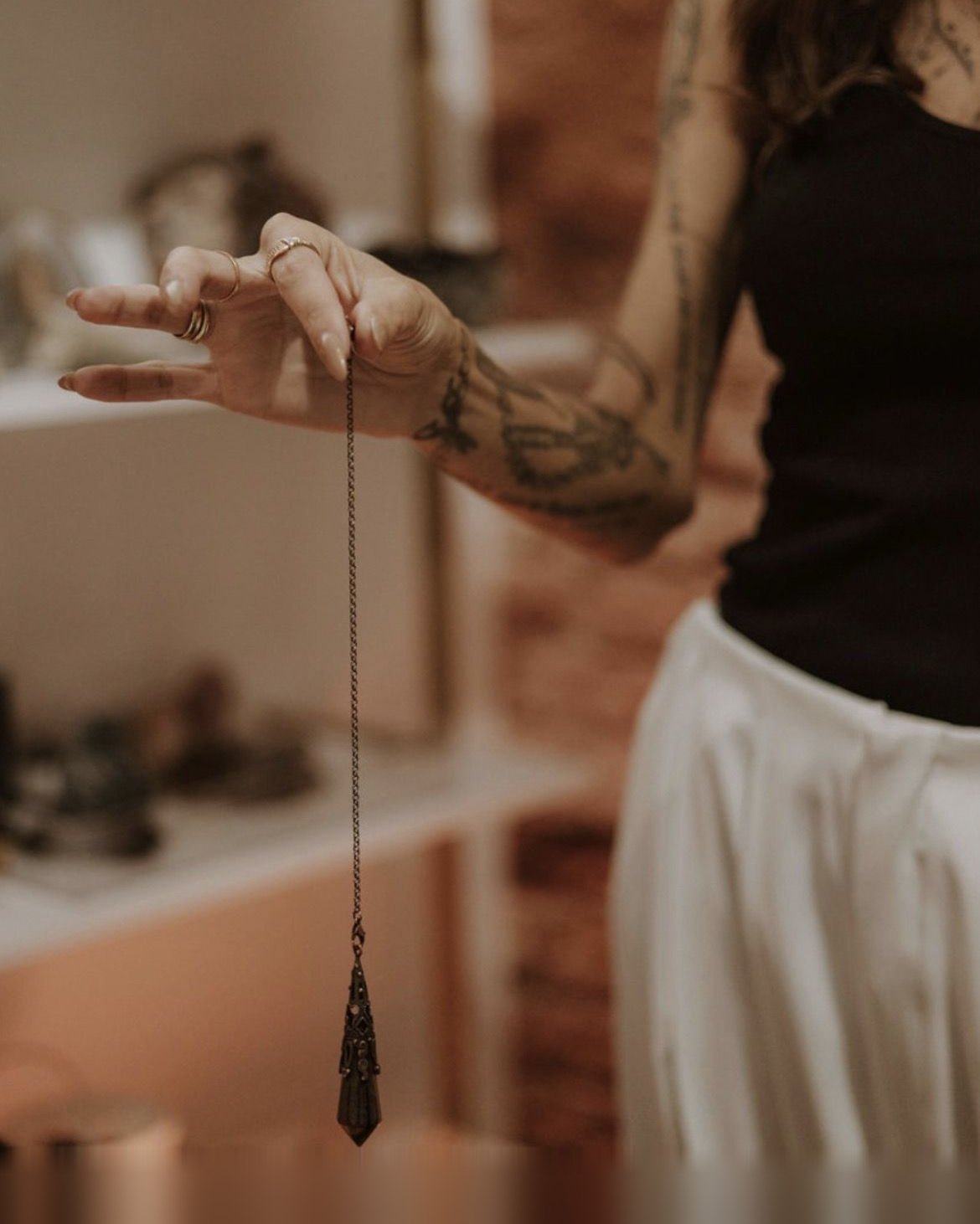 A pendulum held in hand during a chakra reading
