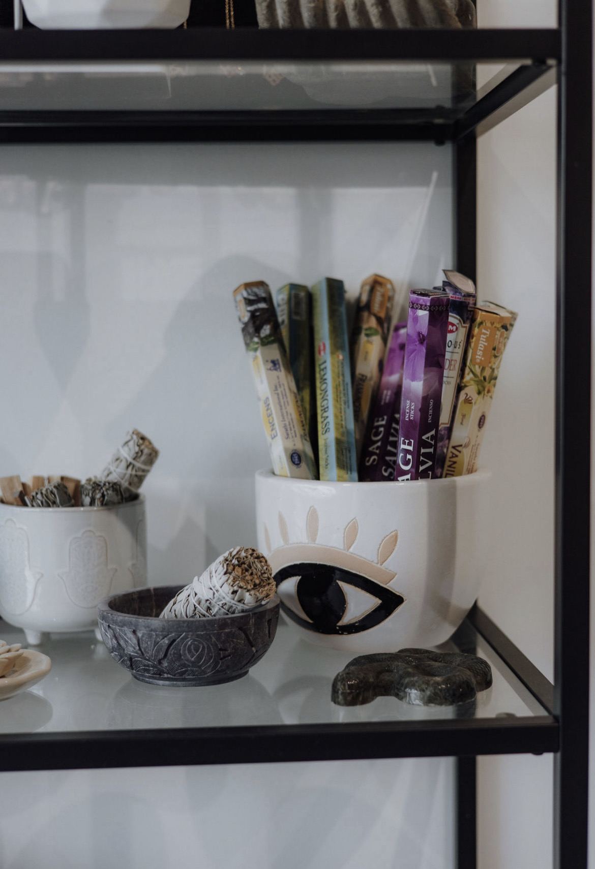 Shelf of sage bundles, incense and ritual tools